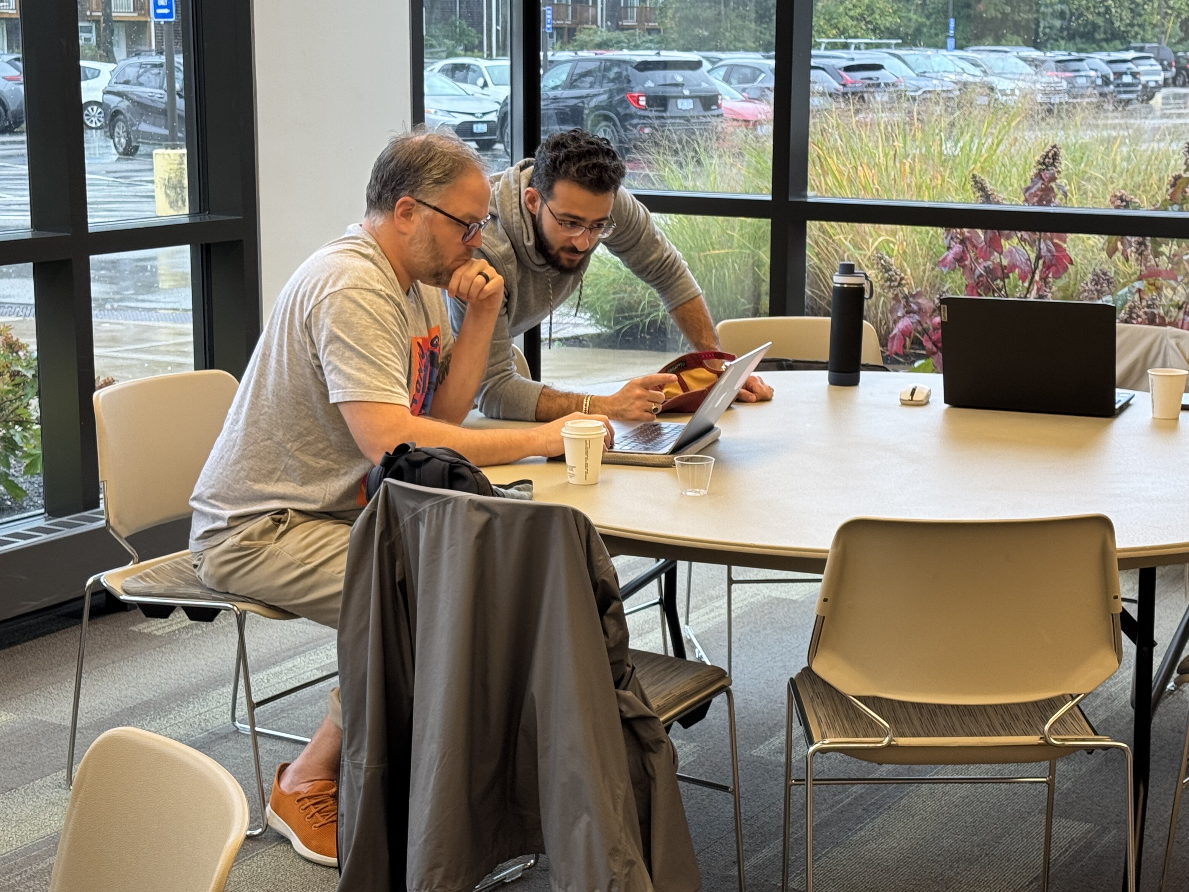 Ayman's pointing out something on a laptop
