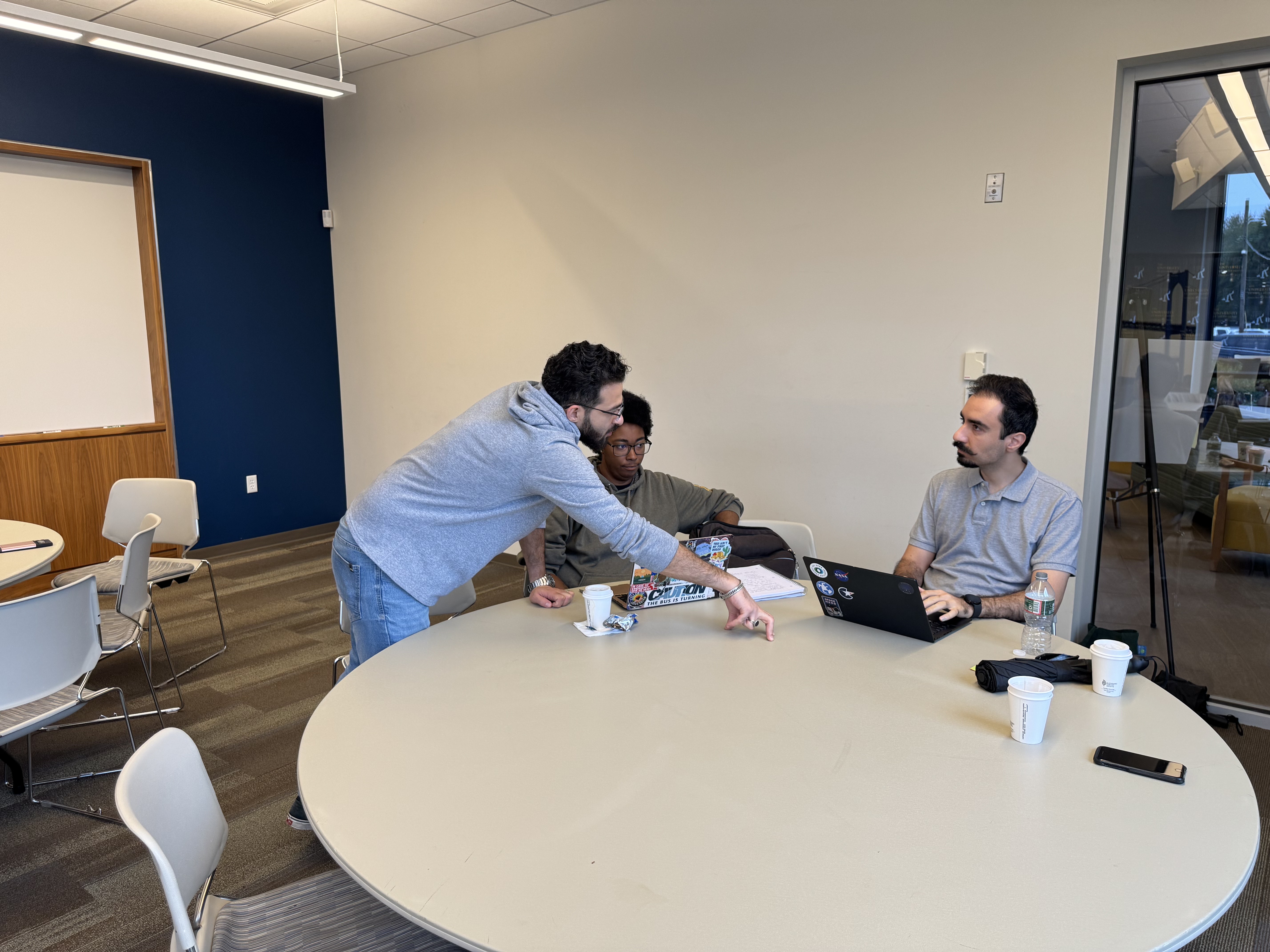 Ayman's pointing out something on a laptop